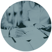 Manos escribiendo en documentos financieros durante el diseño de la estrategia personalizada.