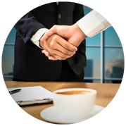 Asesor financiero y cliente sellando acuerdo con un apretón de manos.